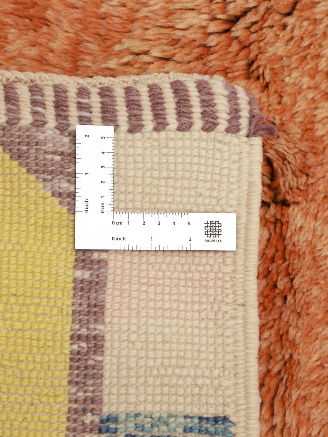 Een uniek, handgeknoopt Berber Marokkaans tapijt met levendige geometrische motieven op een lichte achtergrond.