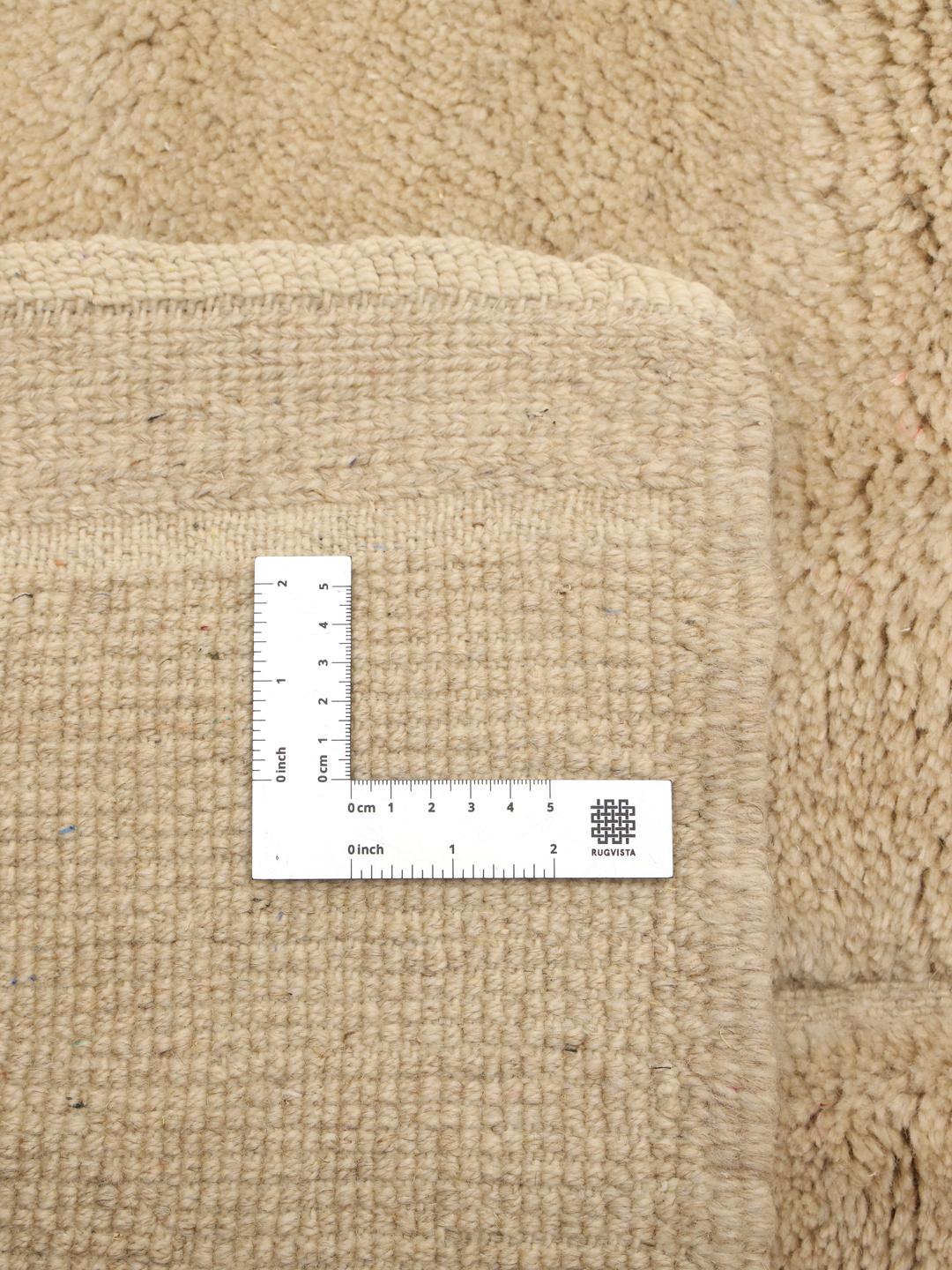 Håndknyttet beige marokkansk tæppe med et tekstureret reliefmønster
