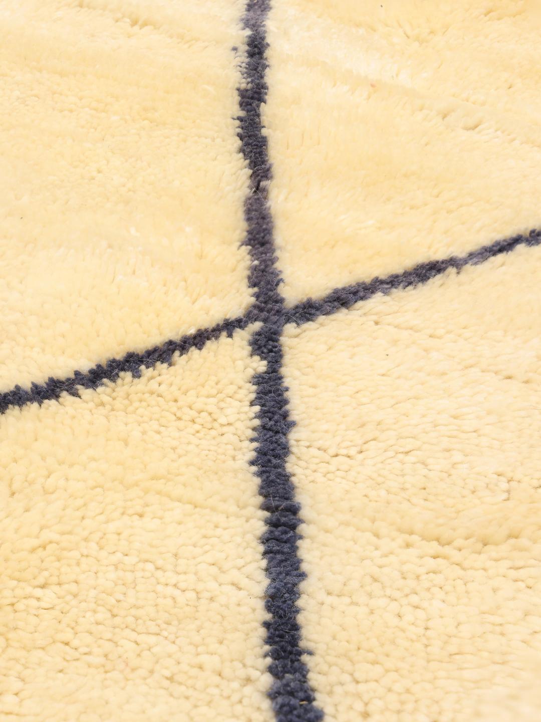 Handgeknoopt Marokkaans Beni Ourain vloerkleed met een blauw ruitenpatroon op een beige achtergrond
