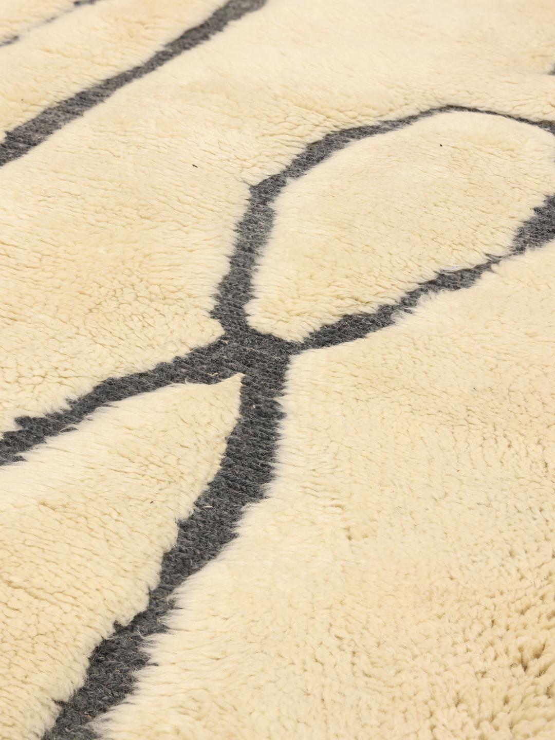Handgeknoopt Marokkaans Berber tapijt met minimalistische donkere patronen op een beige wollen achtergrond