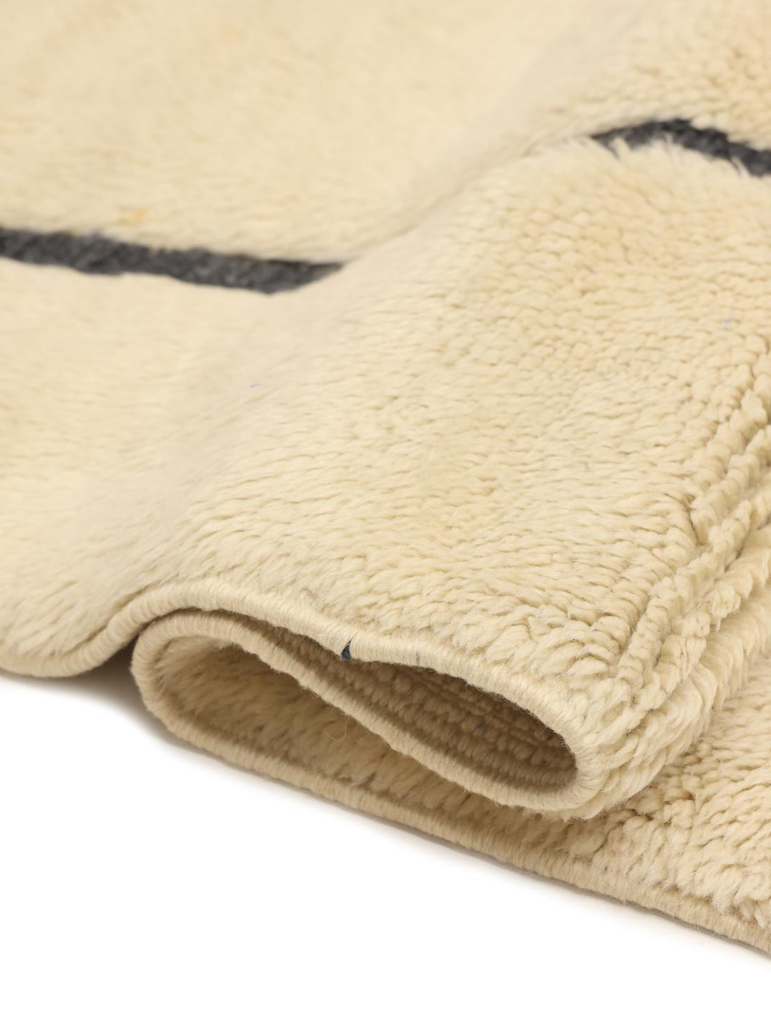 Handgeknoopt Marokkaans Berber tapijt met minimalistische donkere patronen op een beige wollen achtergrond