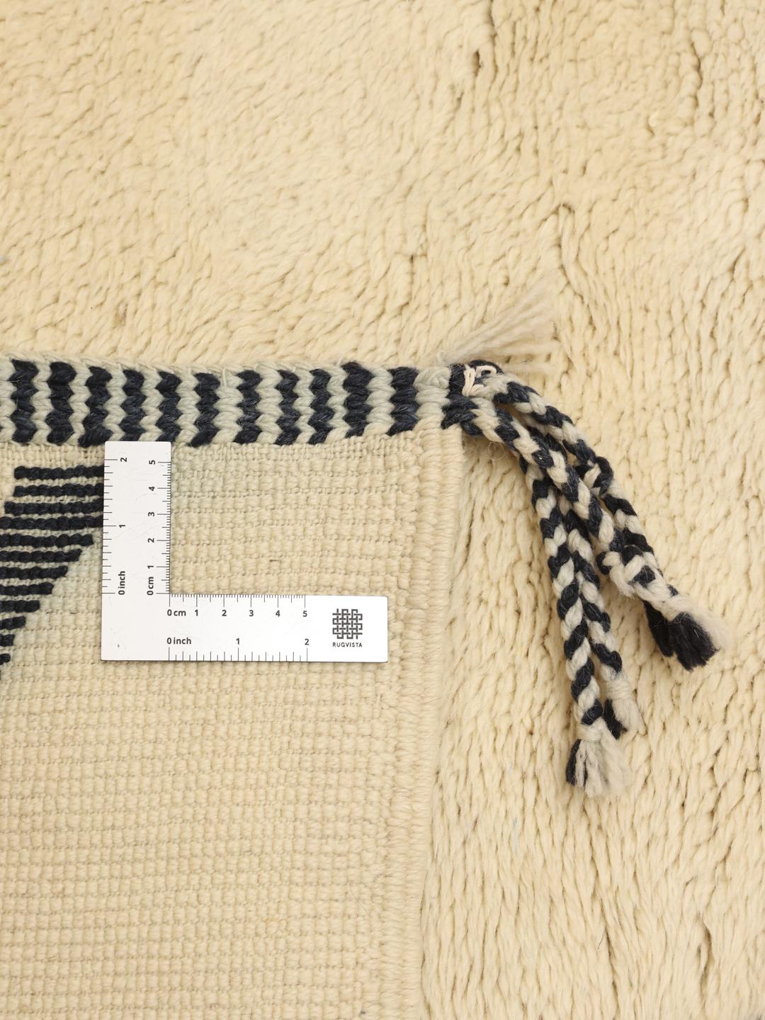 Handgeknoopt Marokkaans Berber tapijt met minimalistische donkere patronen op een beige wollen achtergrond