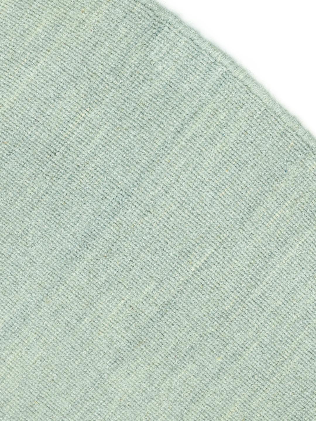 Rond groen vloerkleed in een platgeweven wollen afwerking