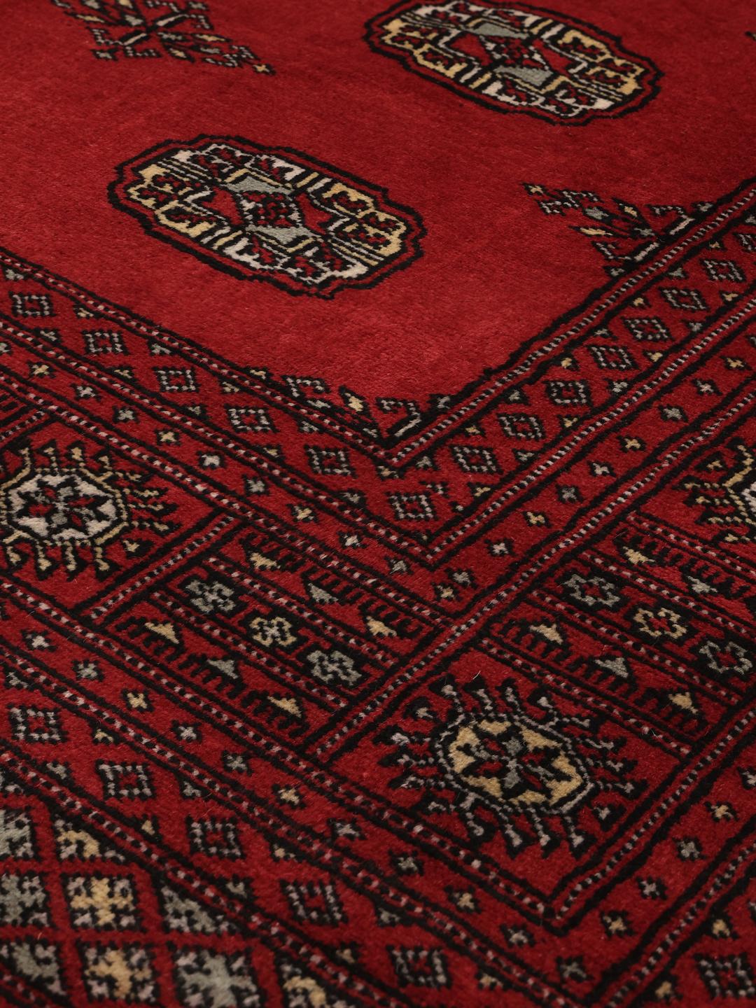 Ręcznie wiązany czerwony dywan Bokhara z Pakistanu z tradycyjnymi geometrycznymi wzorami