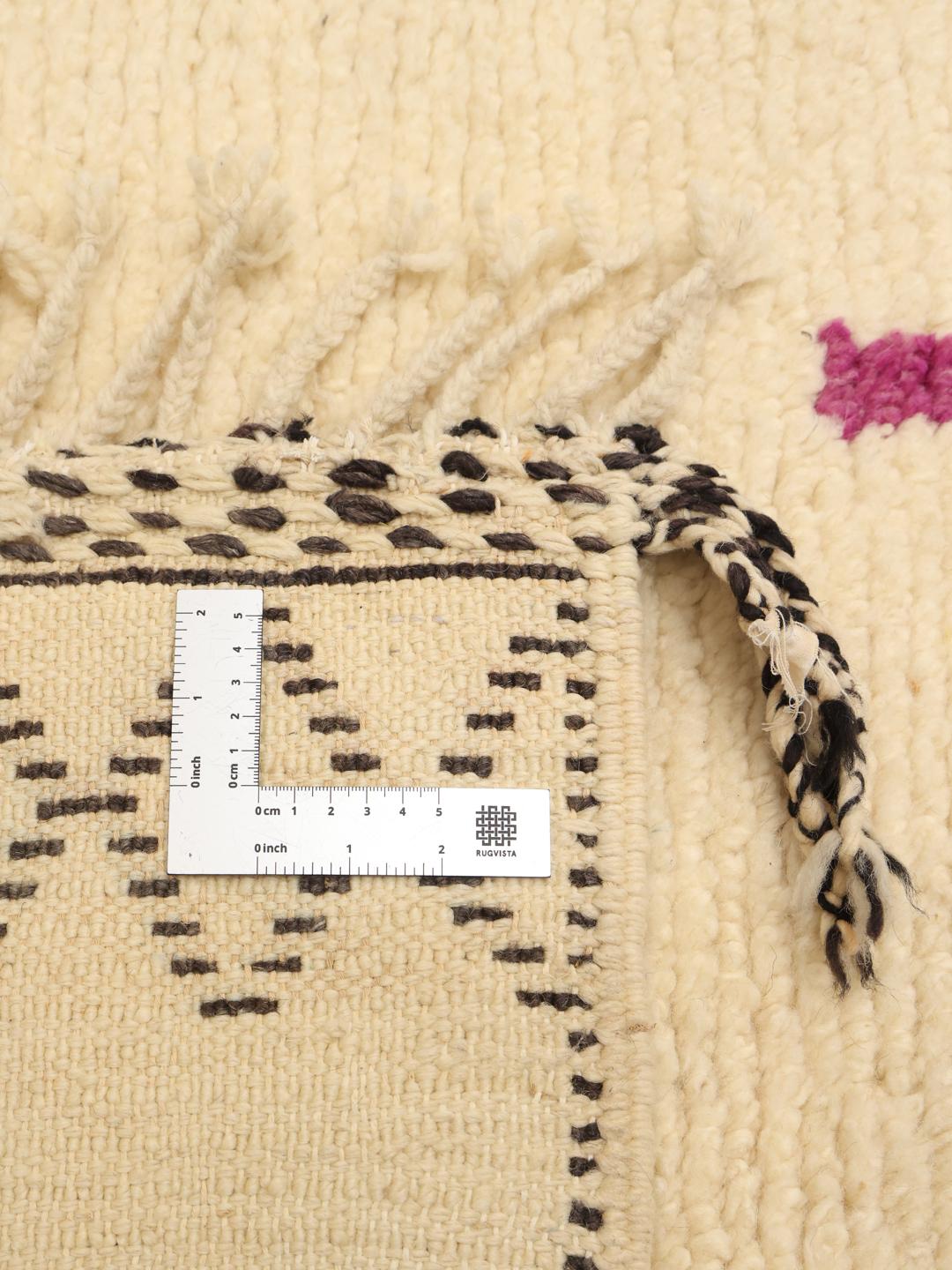 Met de hand geknoopt Berber Marokkaans kleed met kleurrijke geometrische motieven op een beige achtergrond.