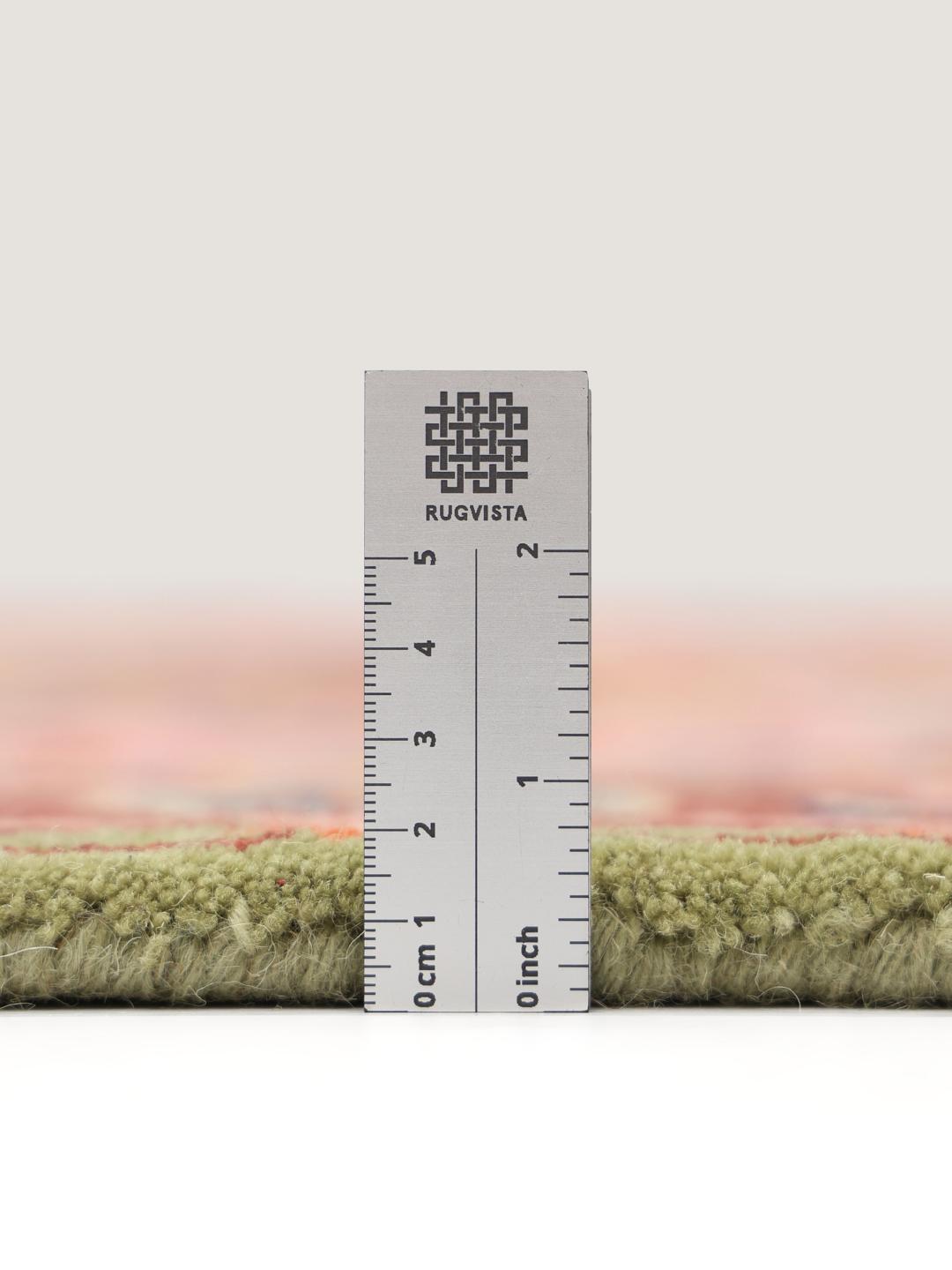 Et rektangulært uldtæppe med et levende lyserødt og rødt blomstermønster.