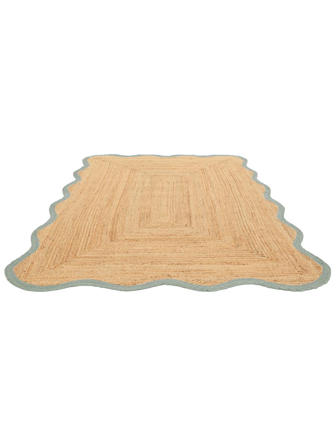 Tapis tissé vert et beige avec un bord festonné