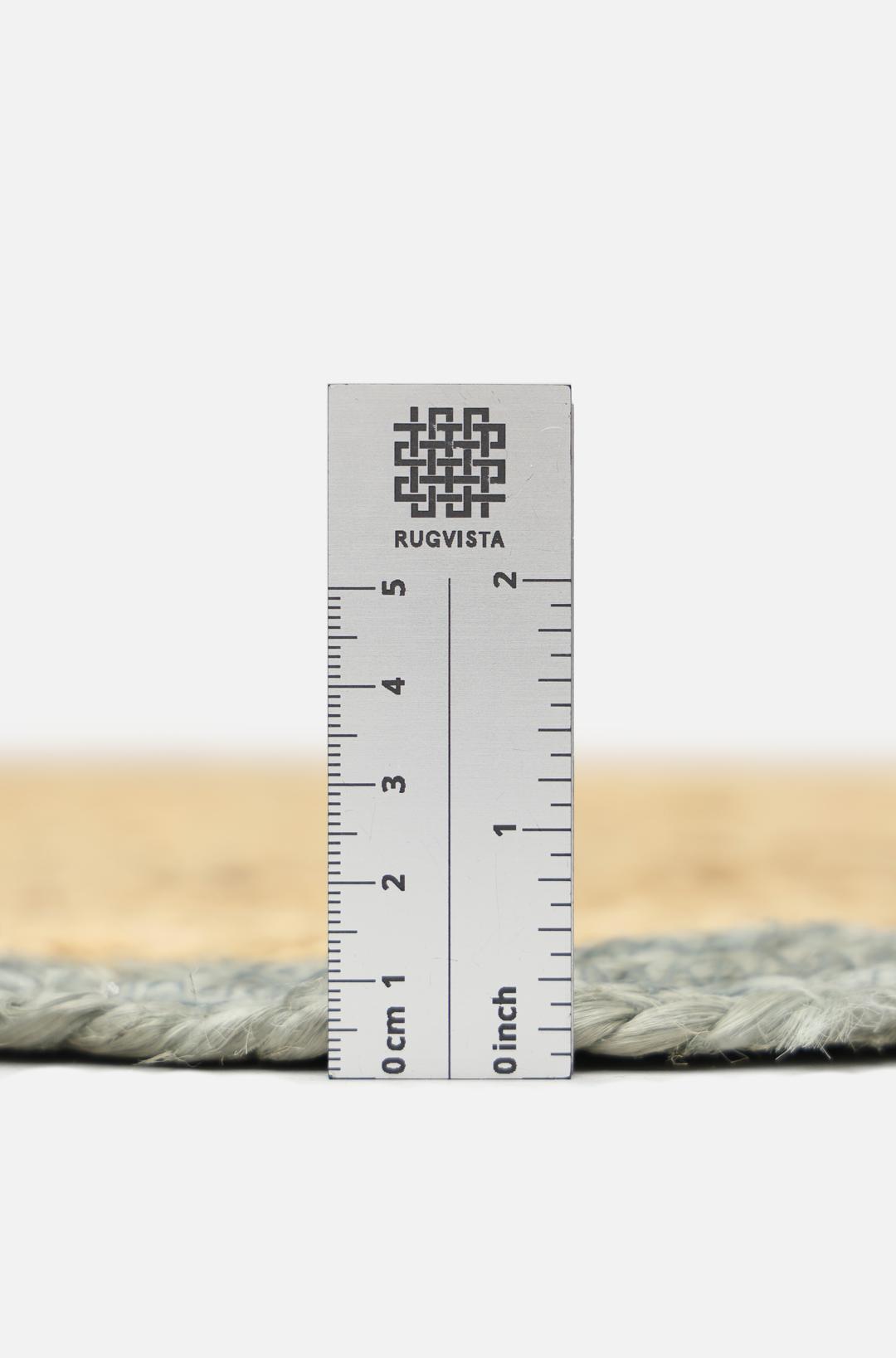 Tapis tissé vert et beige avec un bord festonné