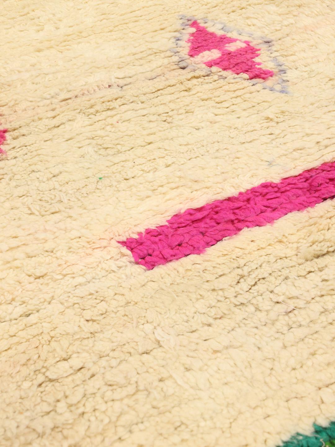 Tapis marocain fait main avec des motifs abstraits colorés sur une base crème