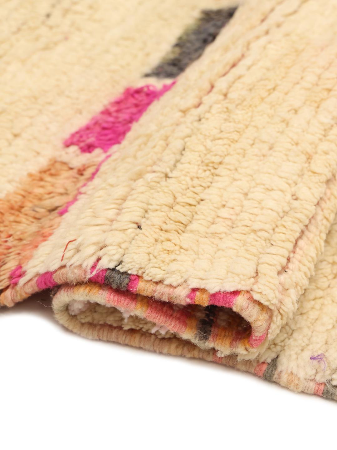 Tapis marocain fait main avec des motifs abstraits colorés sur une base crème
