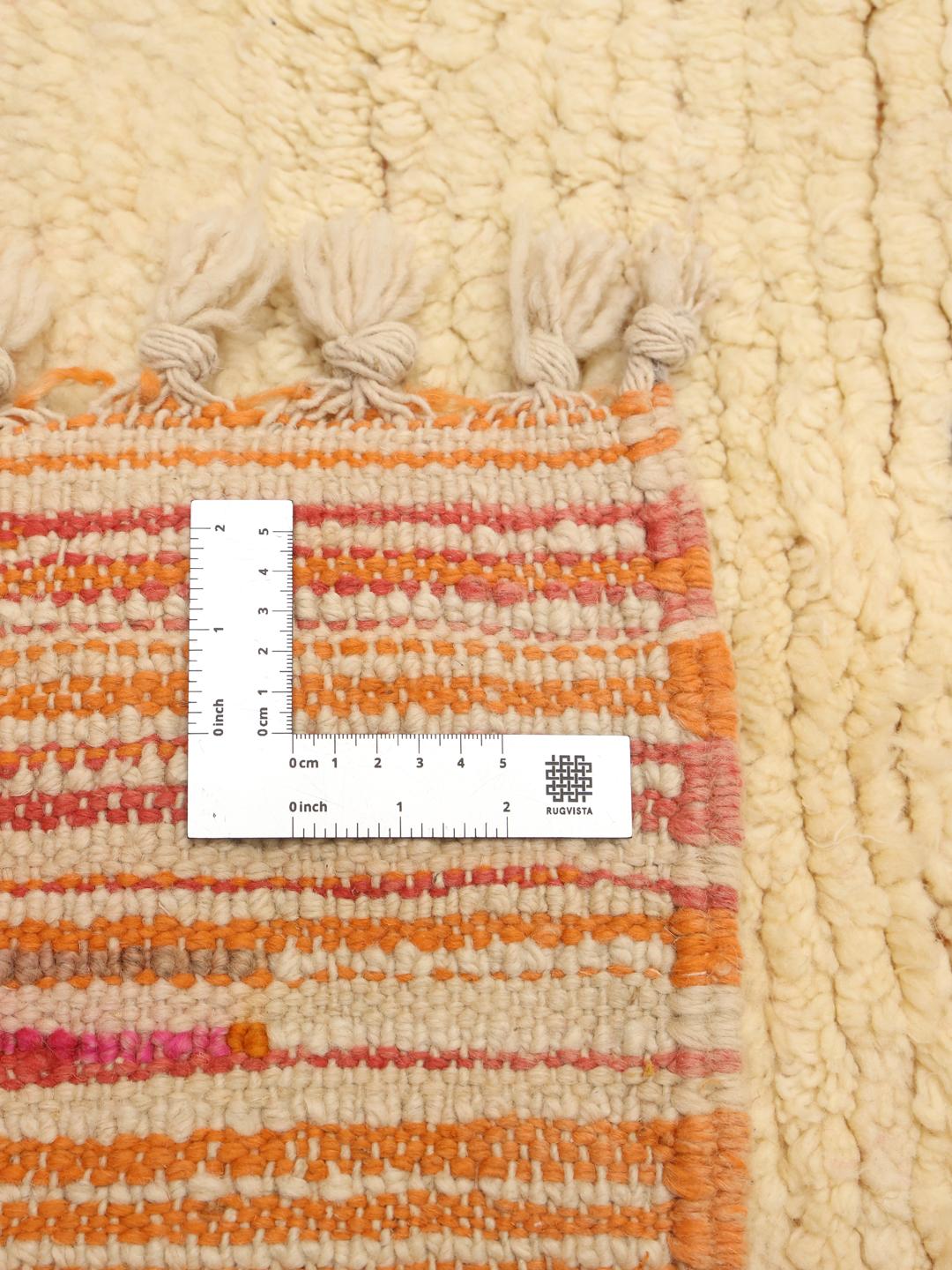 Tapis marocain fait main avec des motifs abstraits colorés sur une base crème