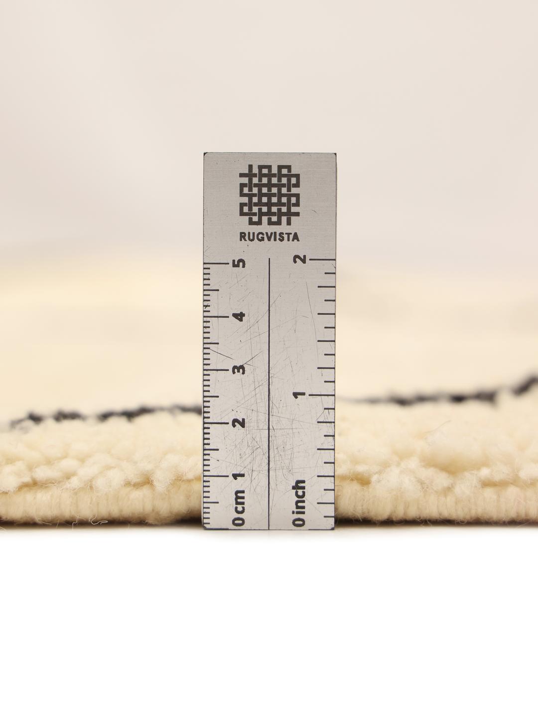 Håndknyttet marokkansk tæppe med diamantmønstre i beige og sort.