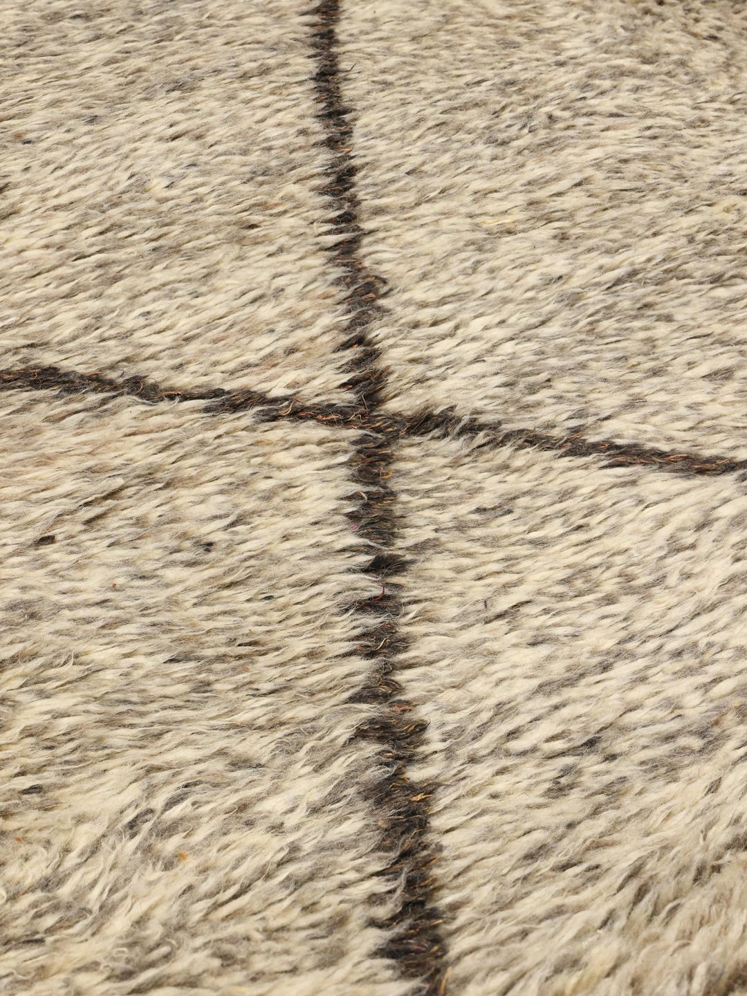 Handgeknoopt Berber Marokkaans tapijt uit Marokko met een beige wollen pool en donker ruitpatroon.