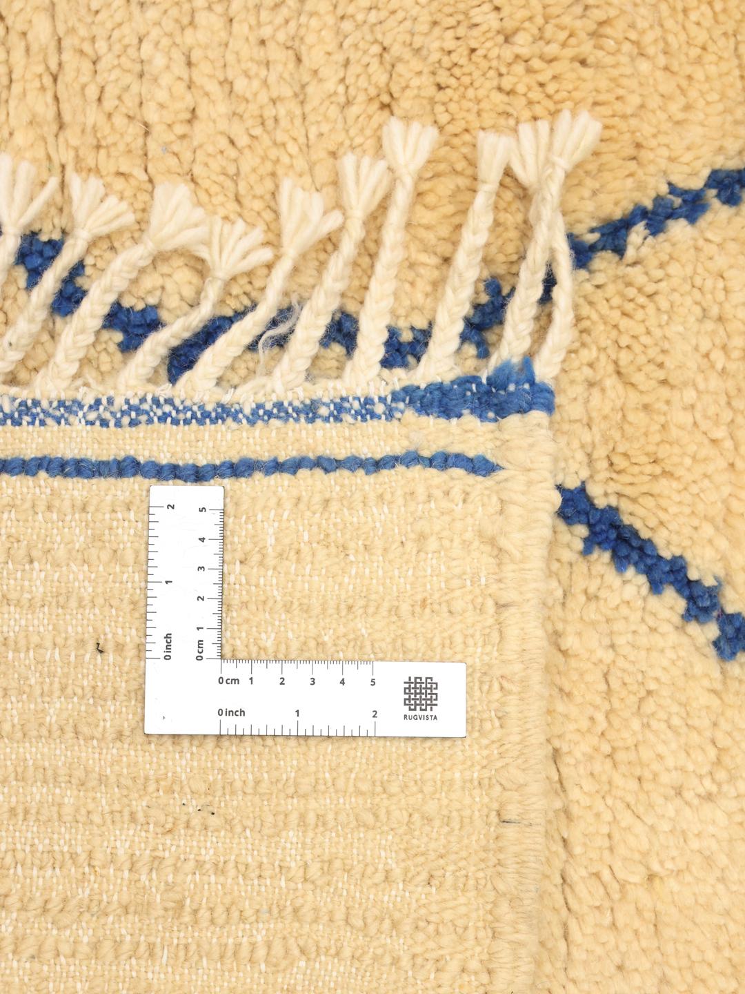 Tapis berbère marocain noué à la main avec une base beige et un motif géométrique en losanges bleus