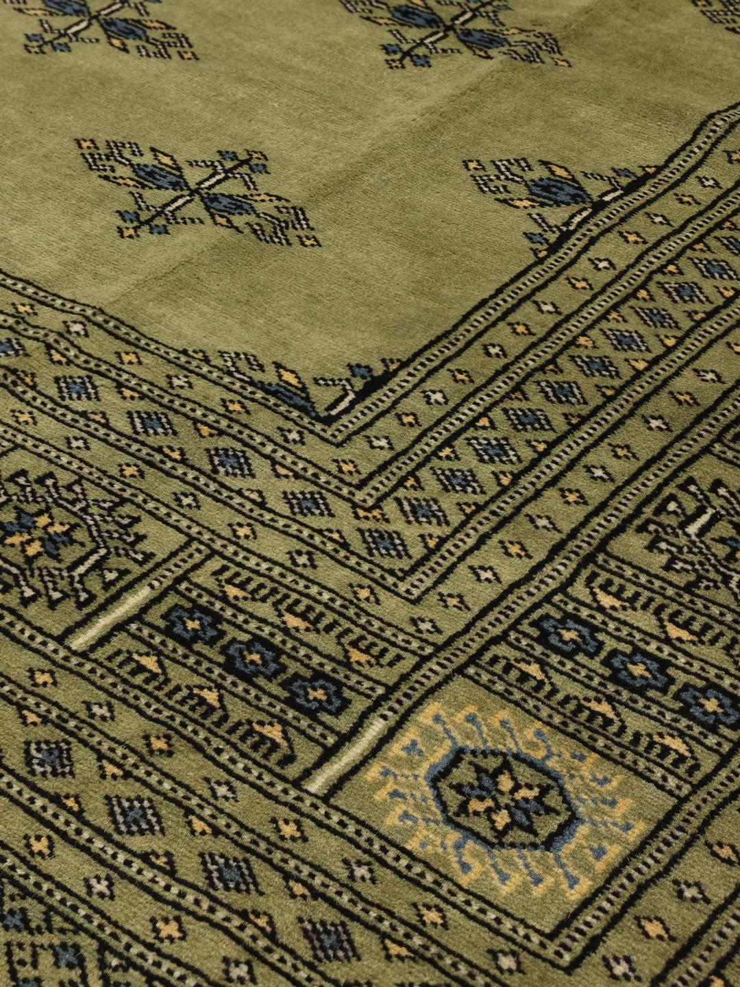 Handgeknoopt Bokhara 2ply tapijt uit Pakistan in een lichtgroene tint met traditionele motieven.