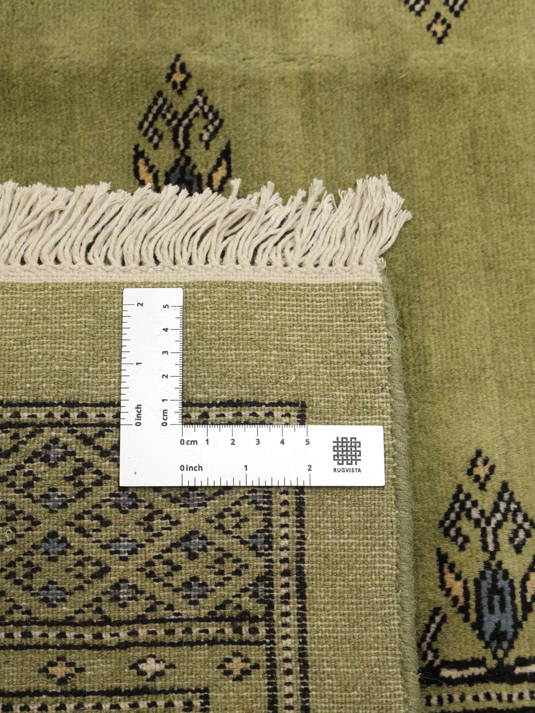 Handgeknoopt Bokhara 2ply tapijt uit Pakistan in een lichtgroene tint met traditionele motieven.