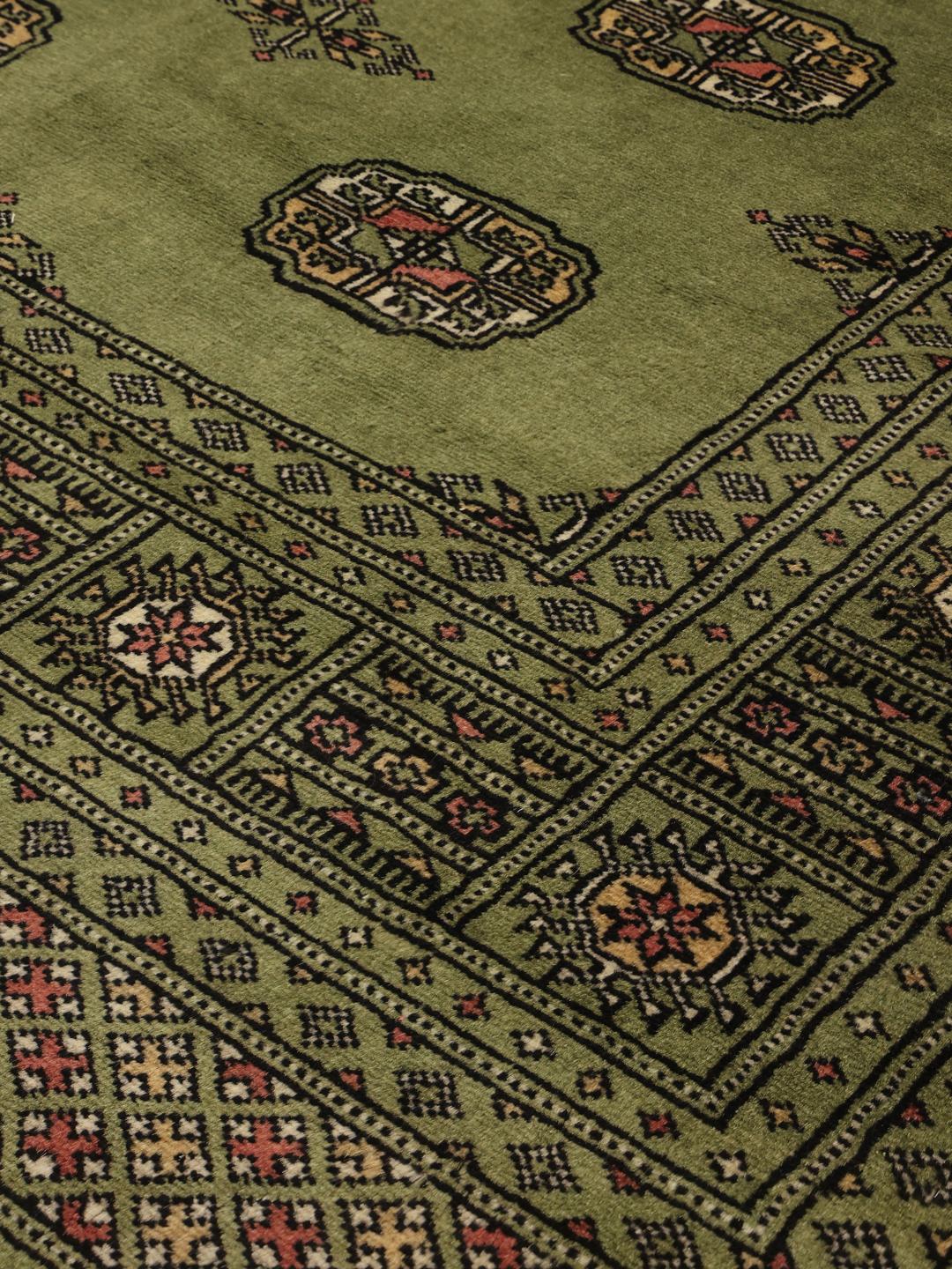 Handgeknoopt vierkant tapijt uit Pakistan met een groen veld en herhalende geometrische motieven
