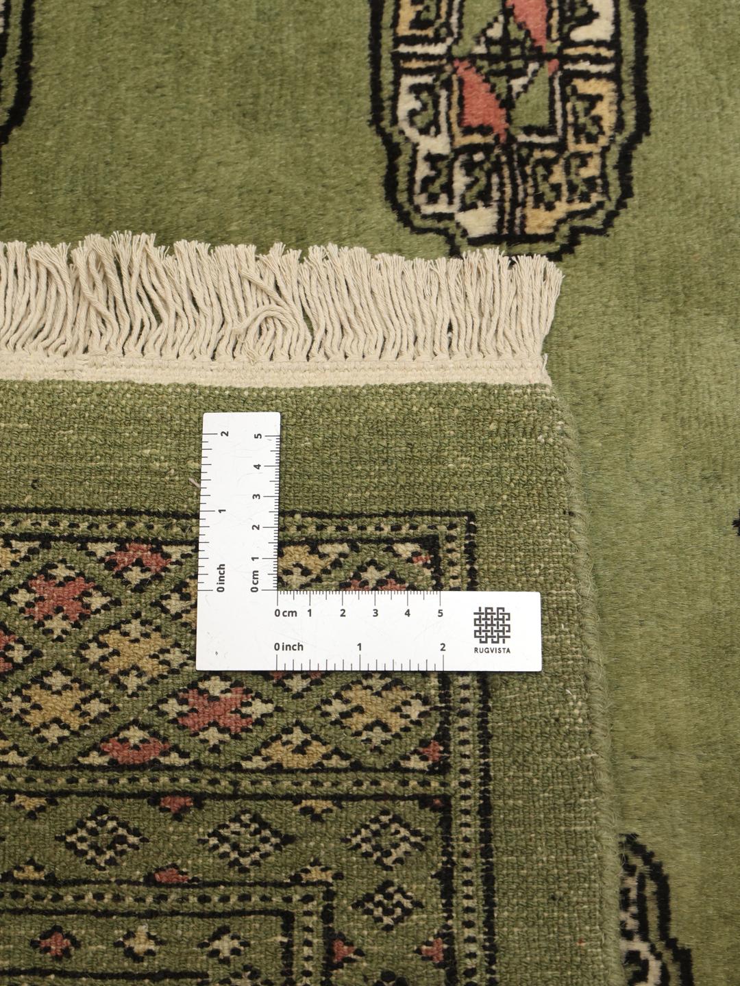 Handgeknoopt vierkant tapijt uit Pakistan met een groen veld en herhalende geometrische motieven