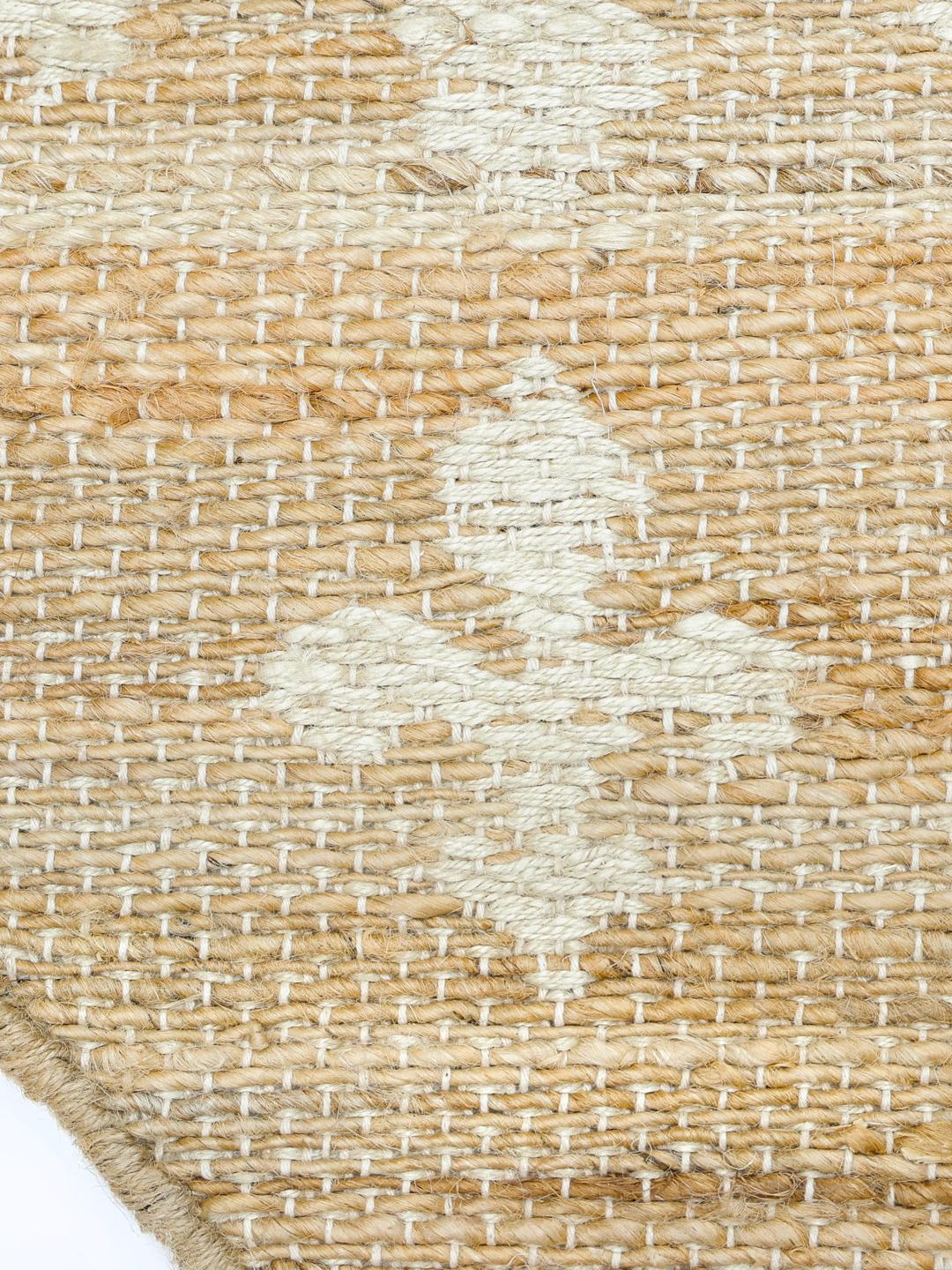 Rundt tæppe i beige og hvid med blomstermønster