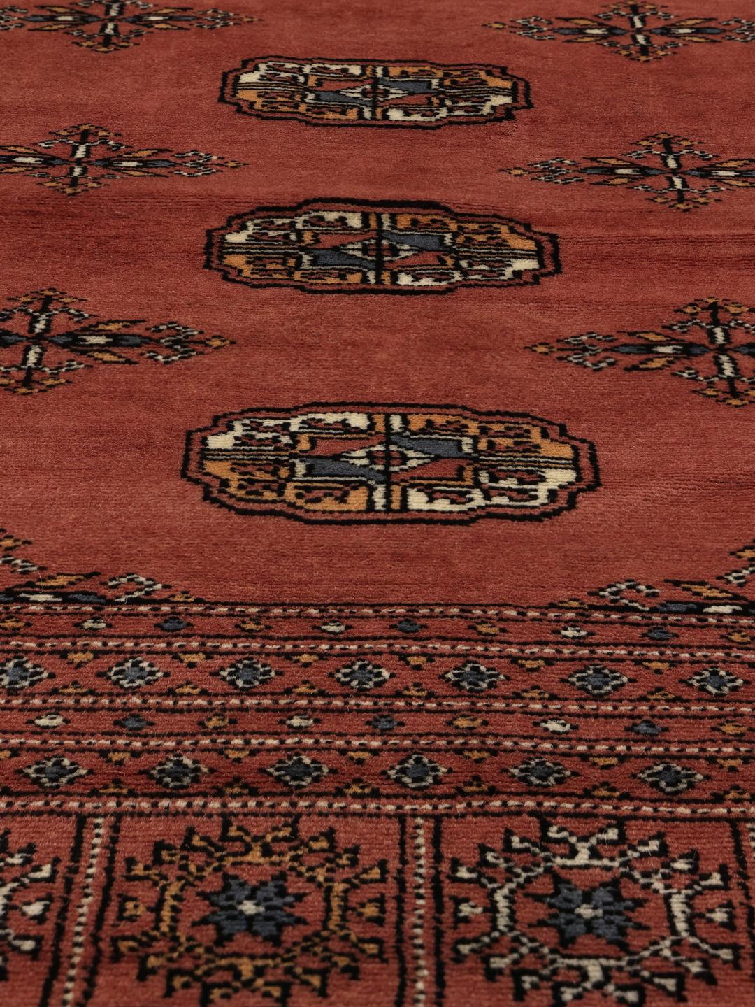 Een vierkant handgeknoopt Pakistaans Bokhara 2ply tapijt in donkerrode wol met traditionele herhalende motieven.