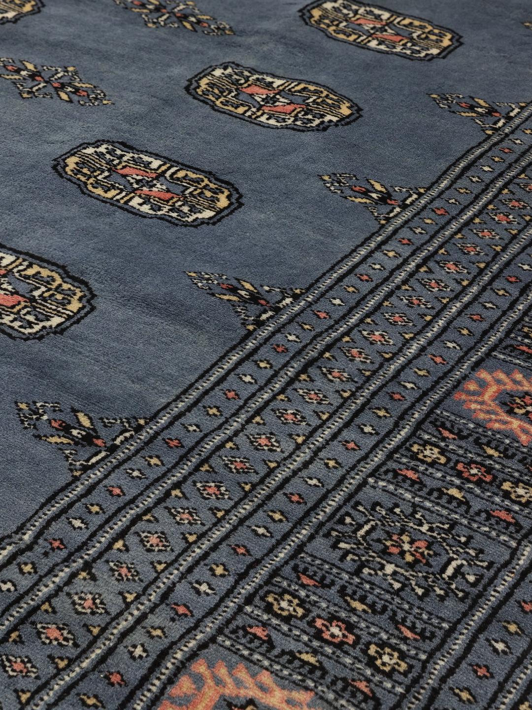 Hand-knotted blue Pakistani Bokhara rug with traditional gul motifs