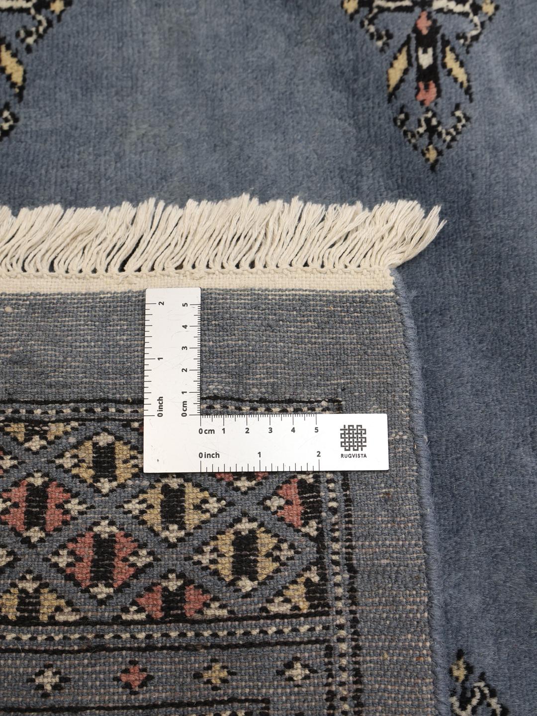 Hand-knotted blue Pakistani Bokhara rug with traditional gul motifs