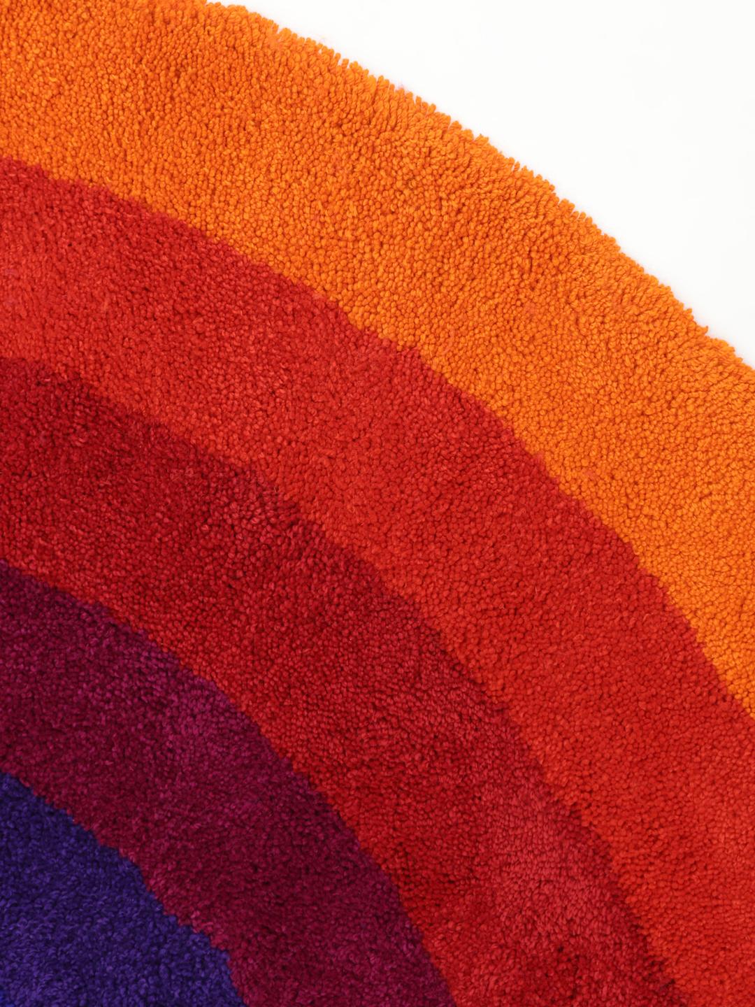 Rond tapijt met concentrische ringen in oranje en meerkleurige tinten
