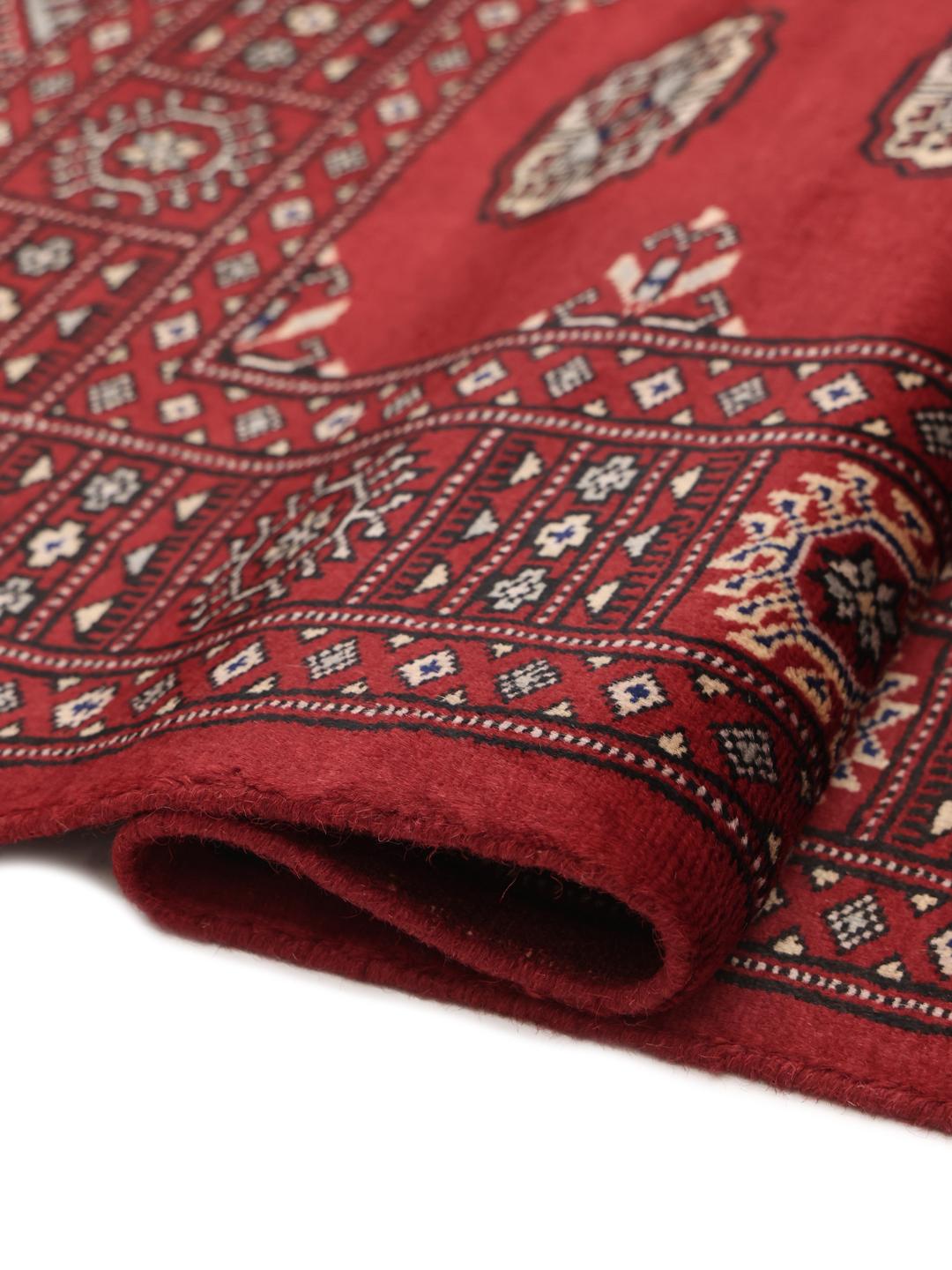 Hand-knotted Pakistani Bokhara rug in dark-red with traditional repeating motifs