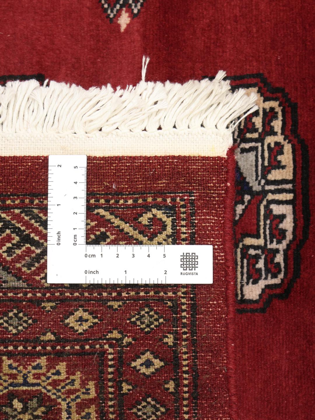 Hand-knotted Pakistani Bokhara rug in dark-red with traditional repeating motifs