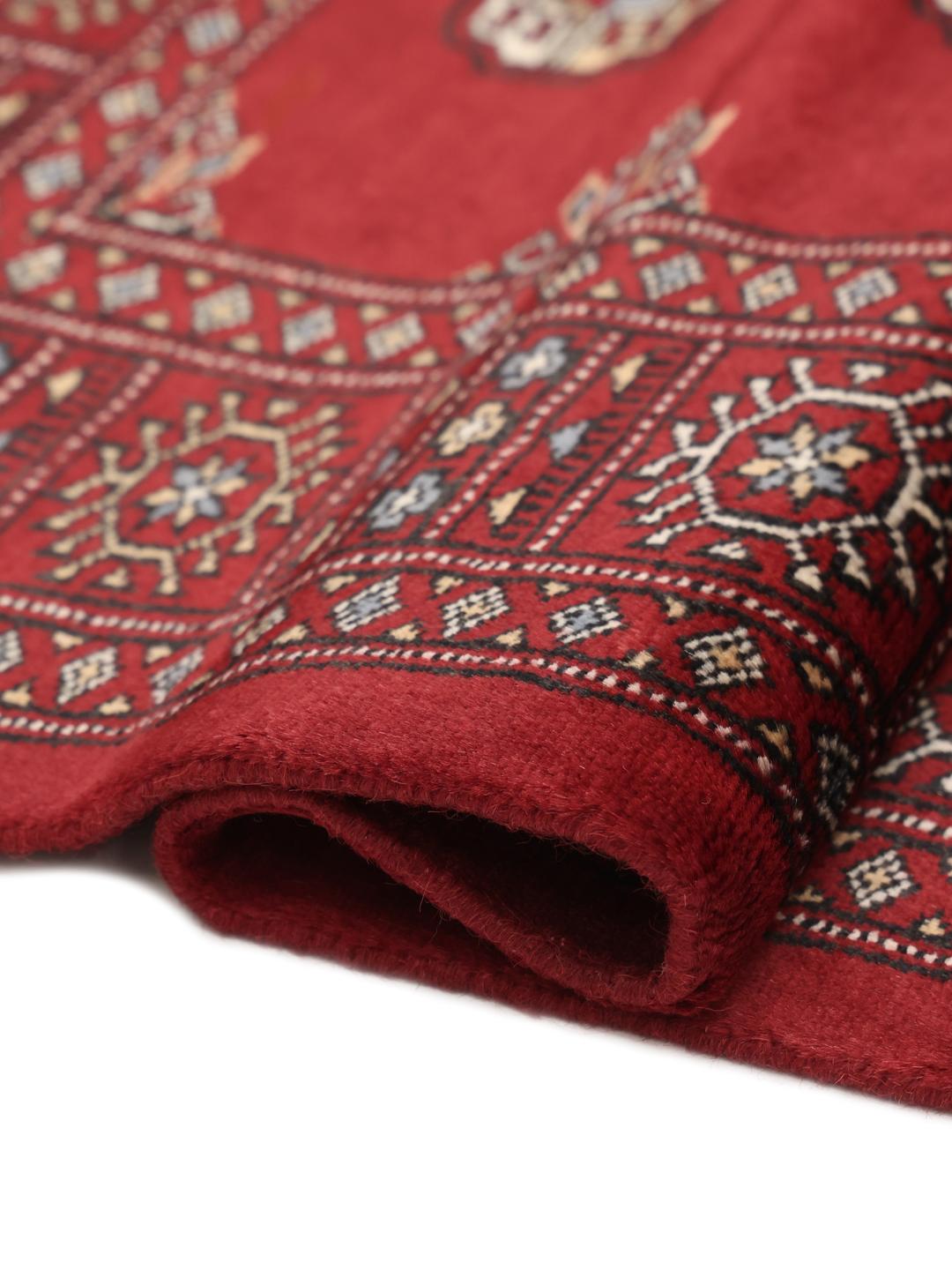 Handgeknoopt donkerrood wollen tapijt uit Pakistan met traditionele gul-patronen