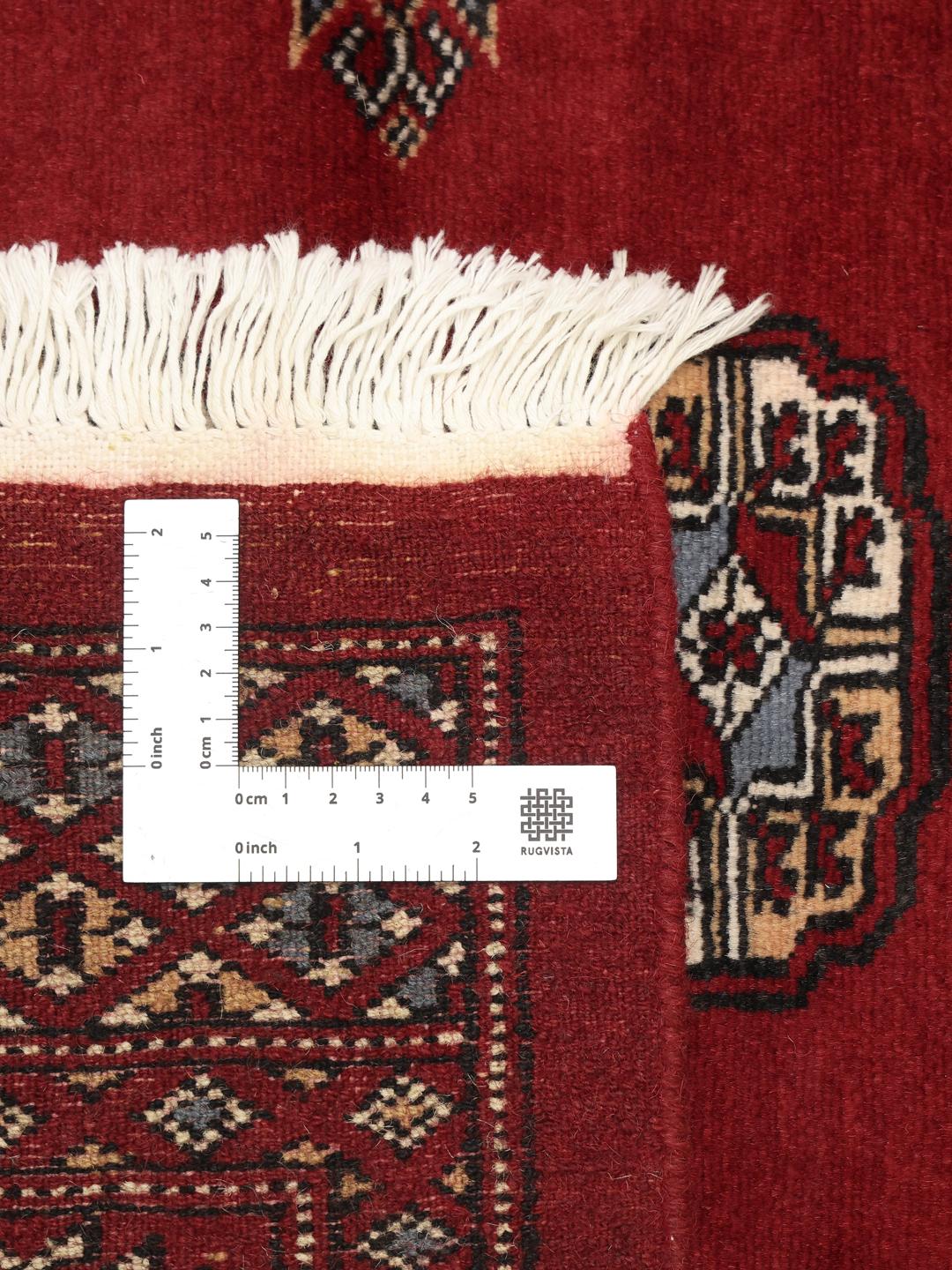 Handgeknoopt donkerrood wollen tapijt uit Pakistan met traditionele gul-patronen