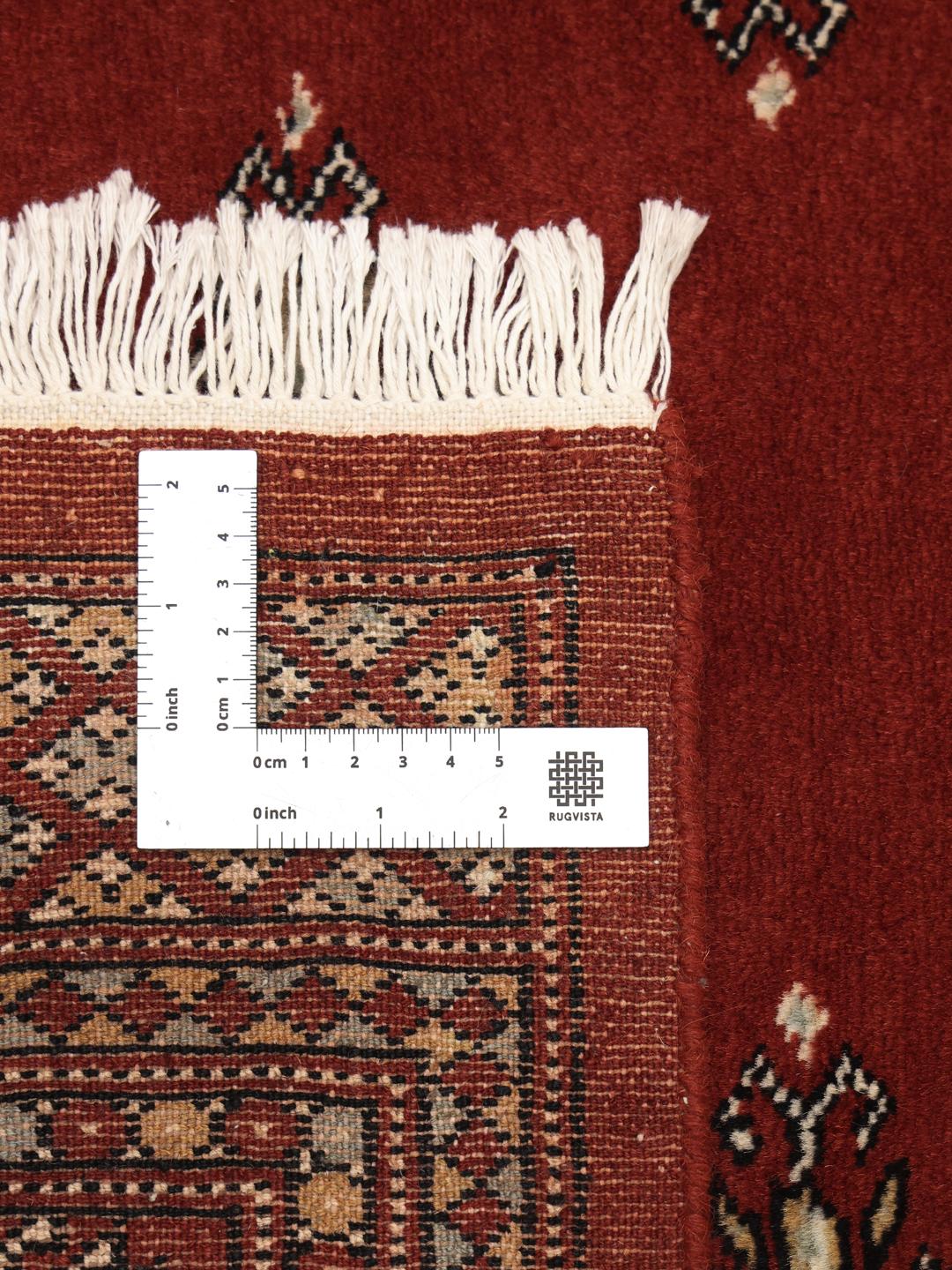 Hand-knotted Pakistani rug with a deep red field and repeating motifs