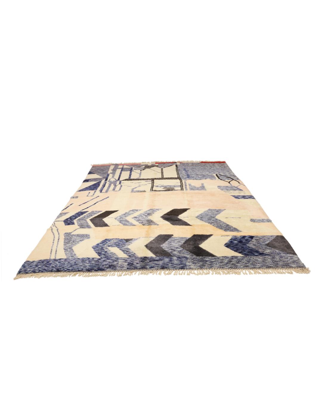 Een groot rechthoekig Marokkaans tapijt met een gedurfd, modern artistiek patroon in blauw, beige en zwart.
