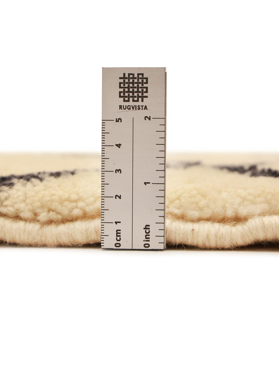 Handgeknoopt Marokkaans Berber Beni Ourain tapijt met geometrische zwarte lijnen op een beige achtergrond.
