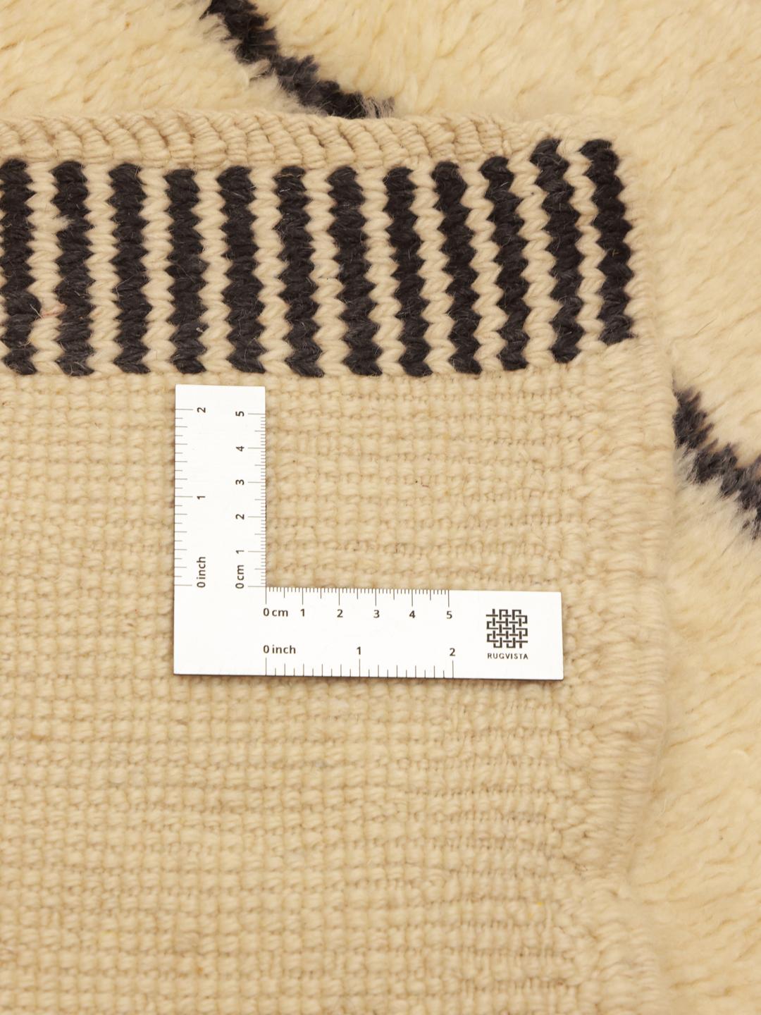 Handgeknoopt Marokkaans Berber Beni Ourain tapijt met geometrische zwarte lijnen op een beige achtergrond.
