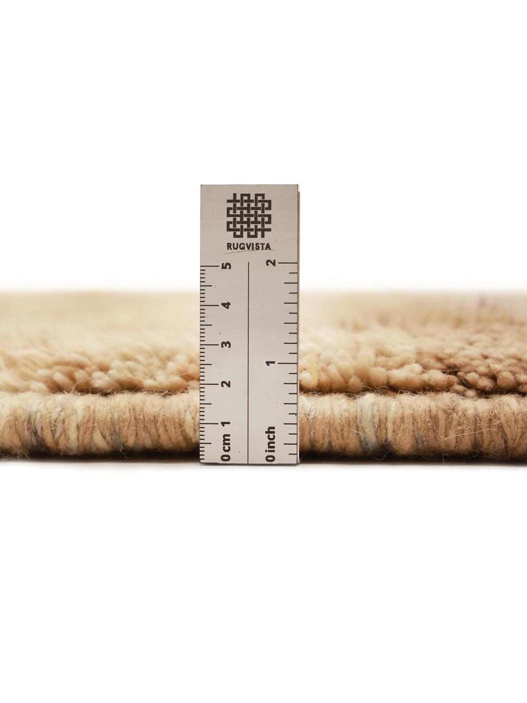 Håndknyttet marokkansk tæppe med abstrakte mønstre i beige og jordfarver.