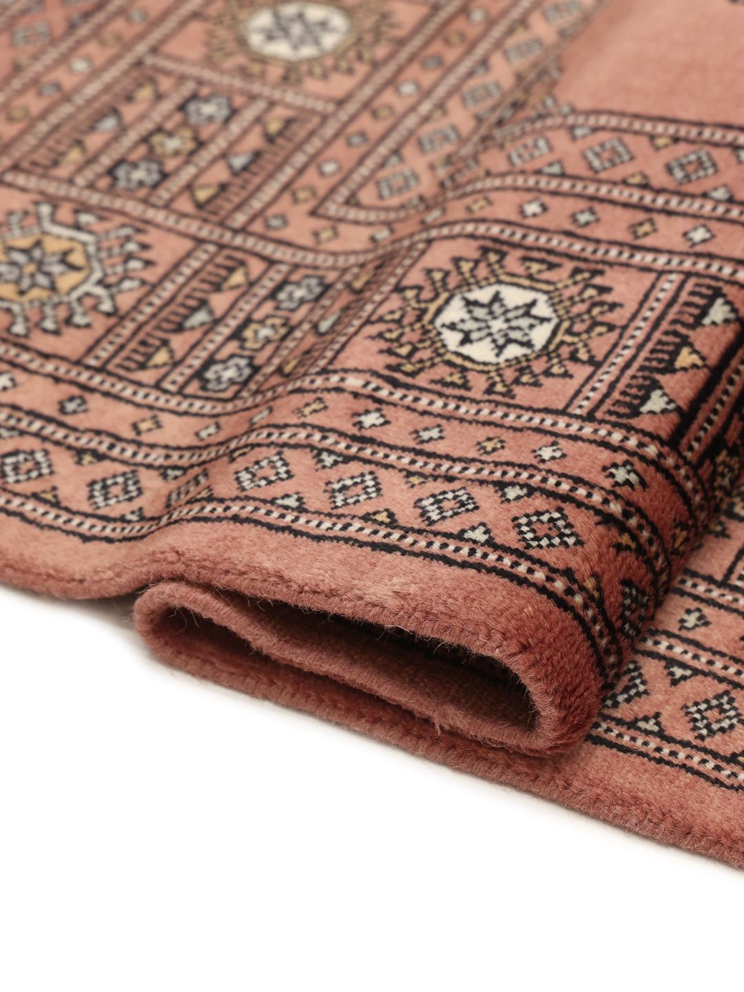 Håndknyttet firkantet tæppe fra Pakistan med et rigt rødt felt og traditionelle motiver.