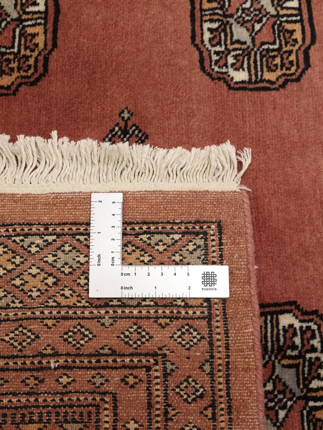 Håndknyttet firkantet tæppe fra Pakistan med et rigt rødt felt og traditionelle motiver.