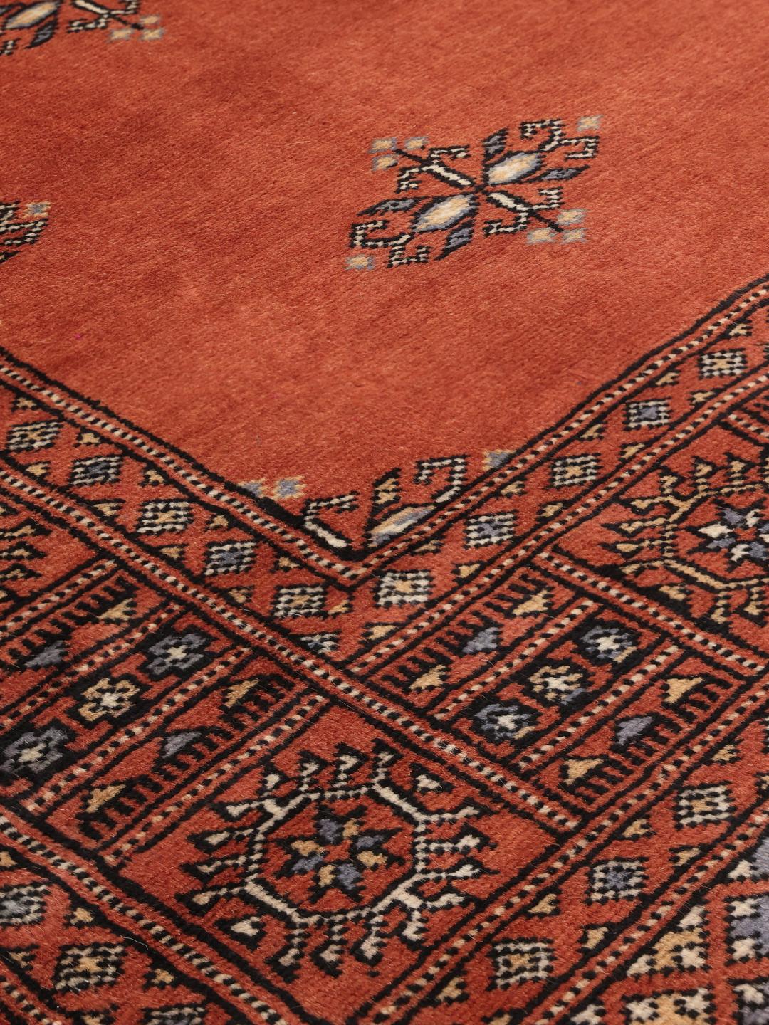 Handgeknoopt rood Bokhara tapijt uit Pakistan met een klassiek geometrisch patroon.
