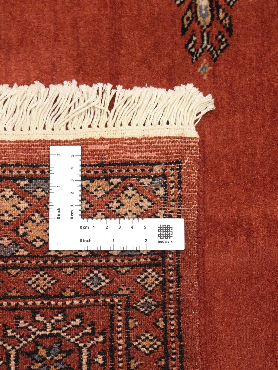 Handgeknoopt rood Bokhara tapijt uit Pakistan met een klassiek geometrisch patroon.