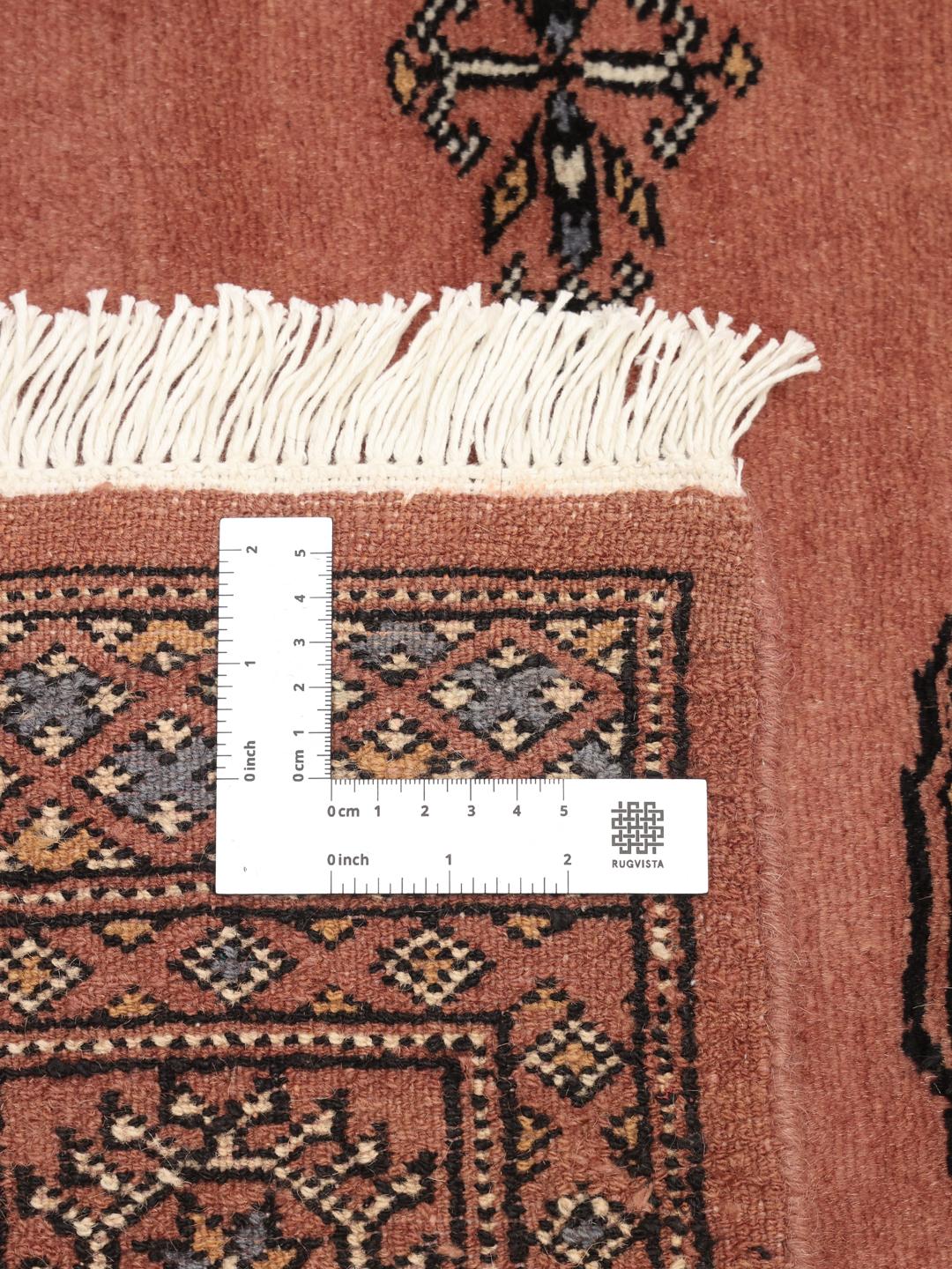 Hand-knotted dark-red Bokhara rug from Pakistan with traditional motifs