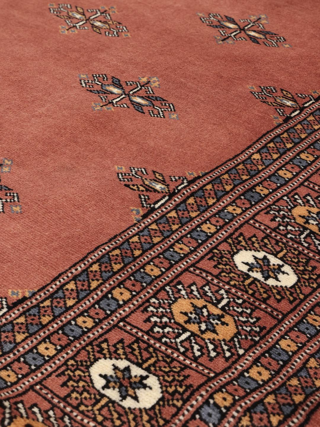 Hand-knotted red Bokhara rug from Pakistan with traditional motifs