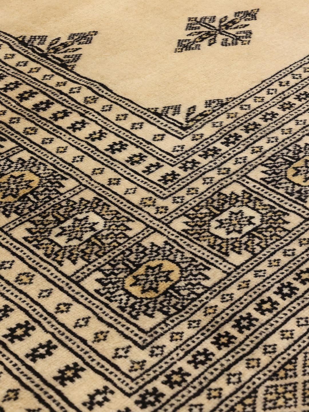Kwadratowy ręcznie wiązany dywan Bokhara z Bliskiego Wschodu w beżowym kolorze z ciemnymi geometrycznymi wzorami.