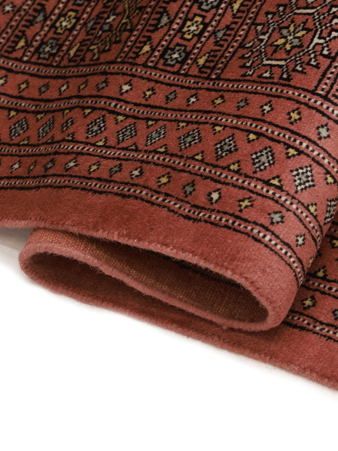 Een vierkant, handgeknoopt Bokhara-tapijt uit Pakistan met een donkerrode wollen pool.