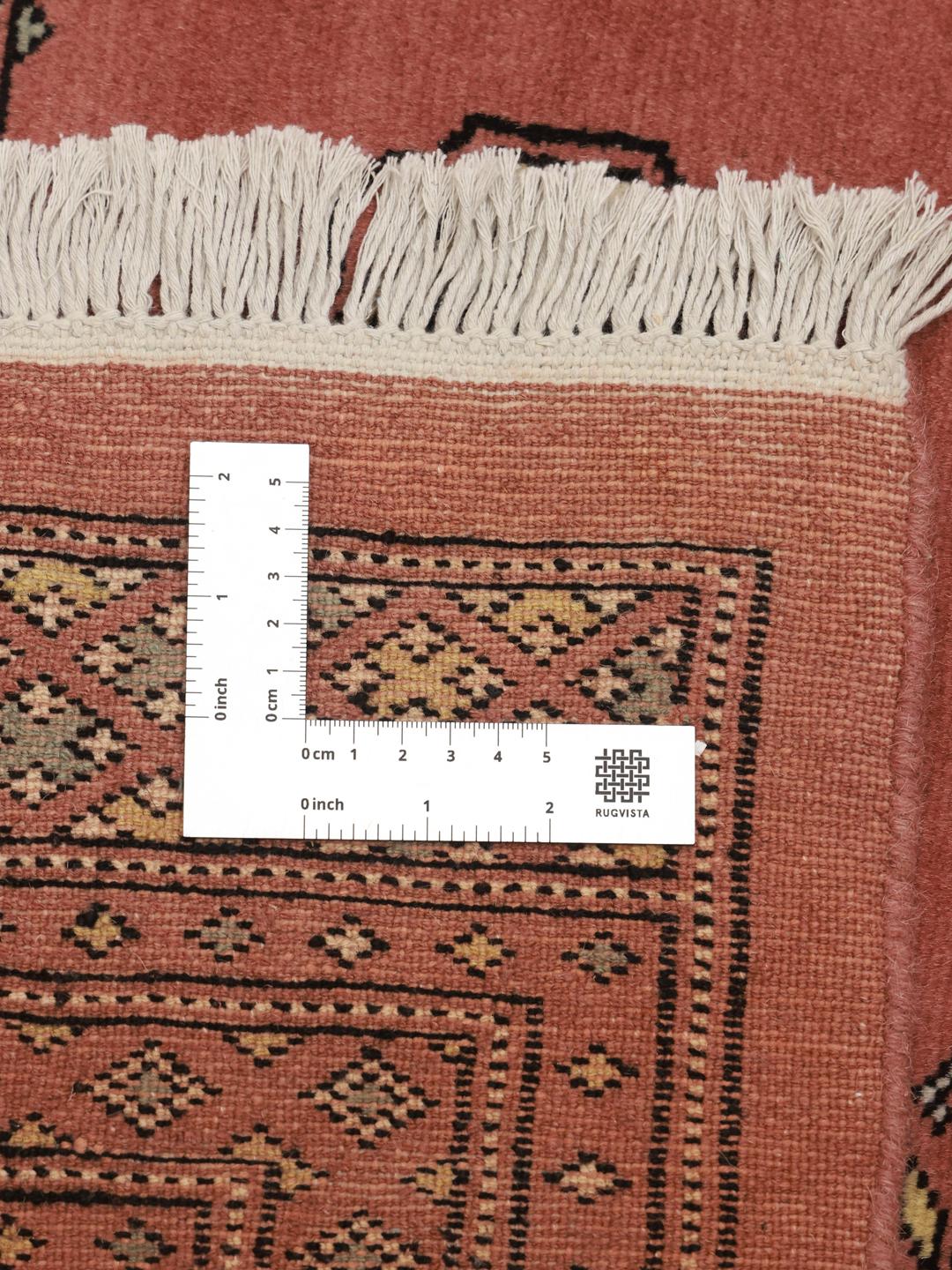 Een vierkant, handgeknoopt Bokhara-tapijt uit Pakistan met een donkerrode wollen pool.