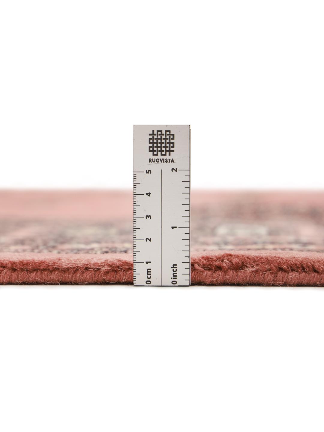 A hand-knotted Pakistani Bokhara rug with a warm red field and geometric motifs