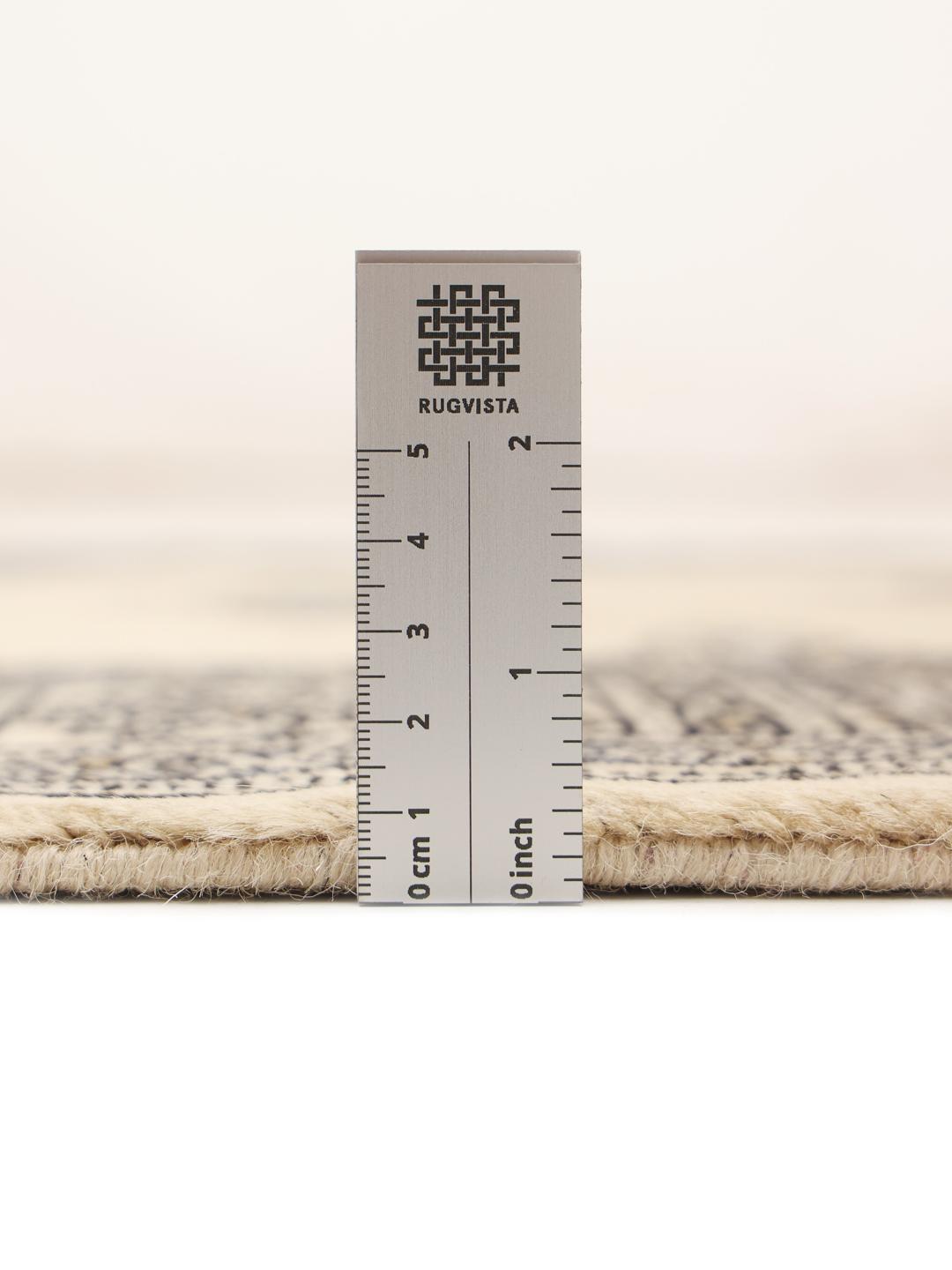 A long, cream-colored Pakistani hand-knotted runner with dark geometric motifs.