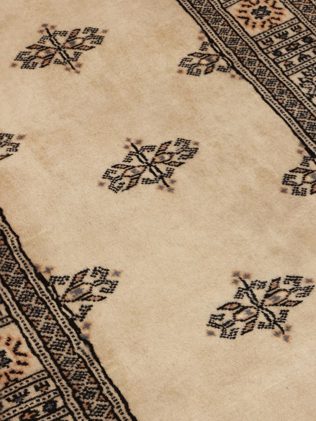 Hand-knotted Pakistani Bokhara runner in beige with intricate dark motifs.