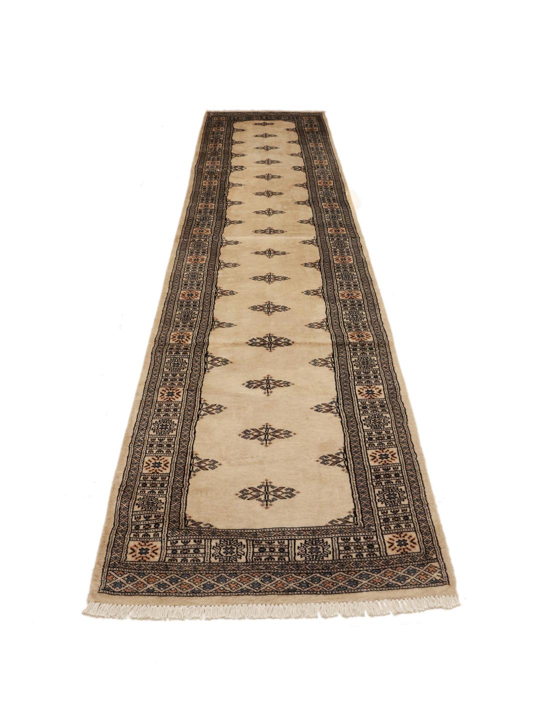 Hand-knotted Pakistani Bokhara runner in beige with intricate dark motifs.