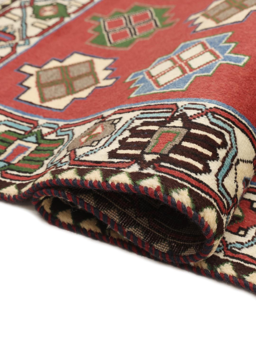 A hand-knotted Shiraz rug from the Middle East in a deep red colour with geometric patterns.